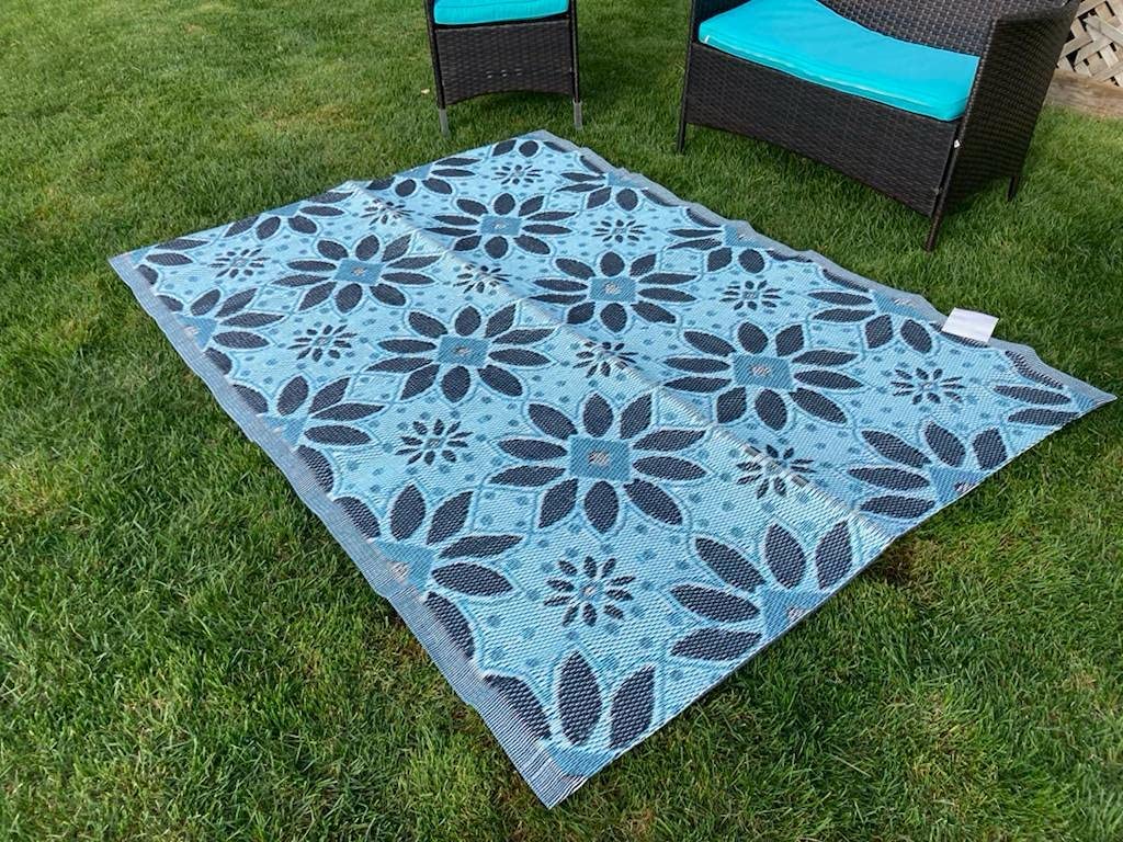 outdoor plastic straw patio rug in blue colour flower designed on grass